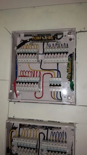 Electrical distribution panels with visible breaker wiring